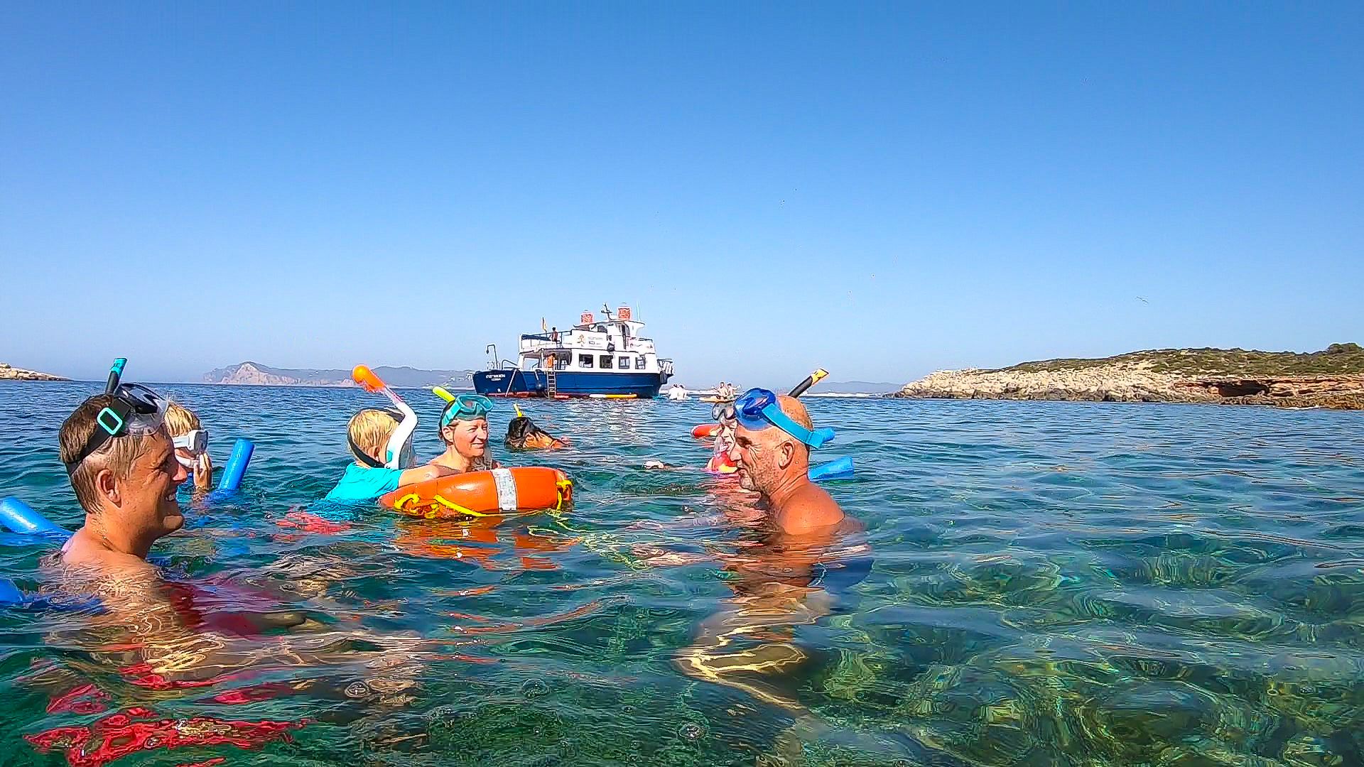 Imagen de una familia haciendo snorkeling en Ibiza durante la excursión familiar en barco de Meet the Sea