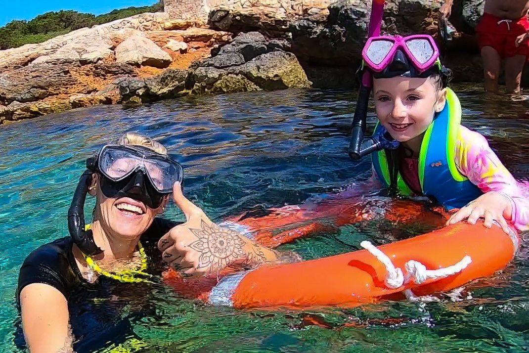 Imagen de uno de los guías de esnorquel de Meet the Sea en el Family Boat trip acompañando a una joven clienta