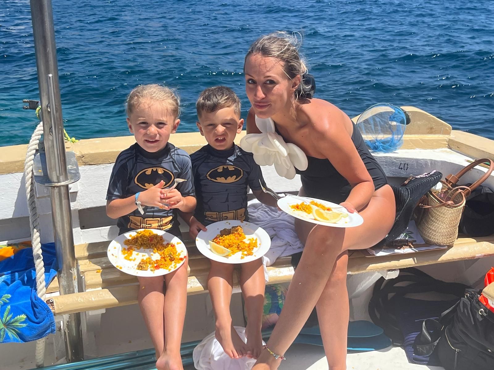 Imagen de dos niños con su madre disfrutandode la paella que cocinamos a bordo en Meet the Sea