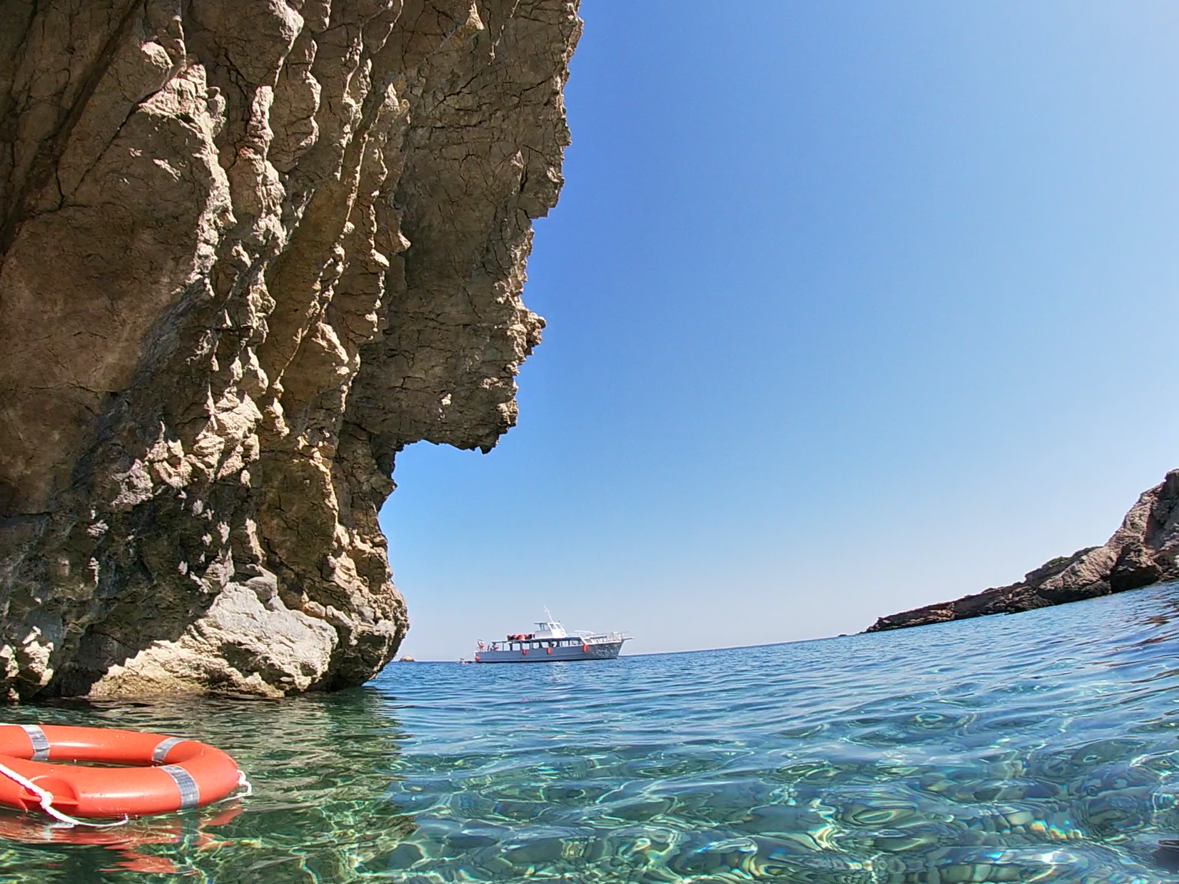 Imagen del barco de Meet the sea fondeado  en Ibiza tomado desde el interior de una cueva que visitamos durante nuestra excursión familiar en barco o Family Boat trip
