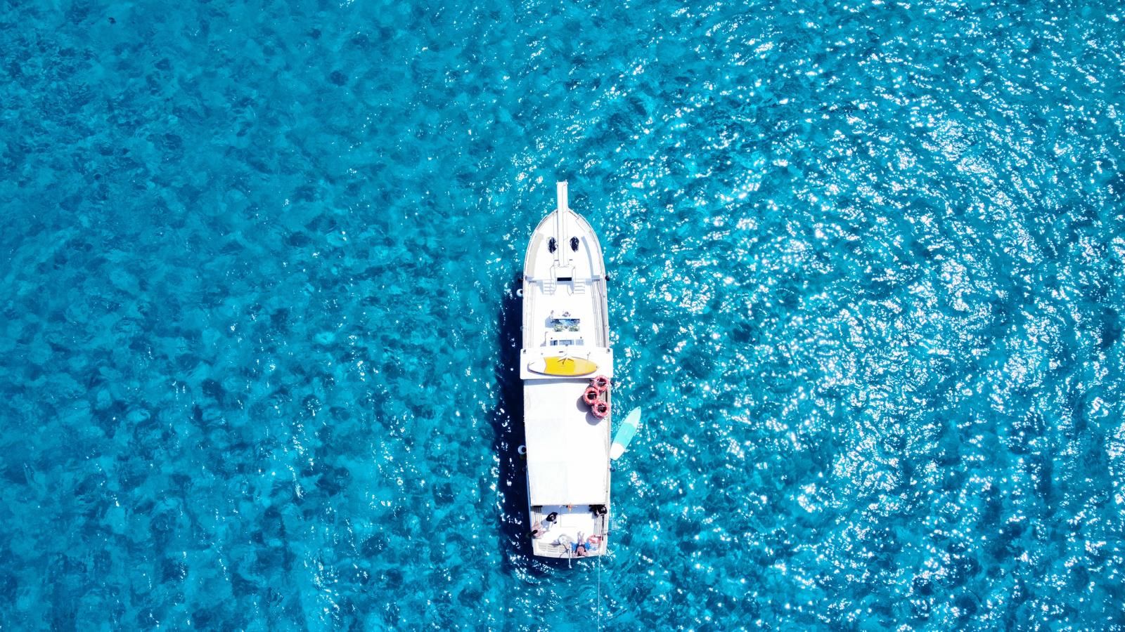 Foto aérea del barco de Meetthe sea en aguas de cala Comte en ibiza