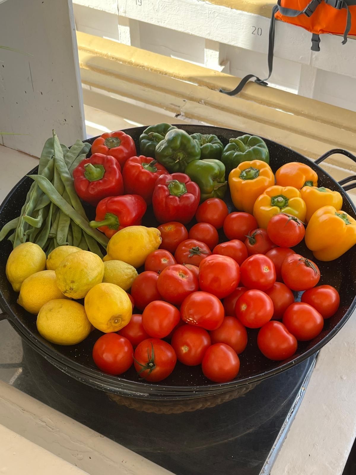 imagen de los productos queutilizamos en Meet the Sea para cocinar. Estrictamente de productores locales, con judias verdes, pimientos rojos, pimientos verdes, tomates y limones de Ibiza.
